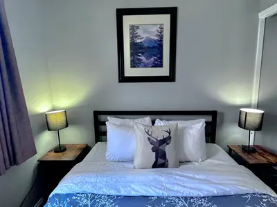 a bedroom with a bed with pillows and two lamps at Canadian Rockies Chalets by Trilink - 2 & 3 Bedroom Condos - Self Check-In - Walking Distance to Downtown - Free Parking - Pet-Friendly - No AC in Canmore