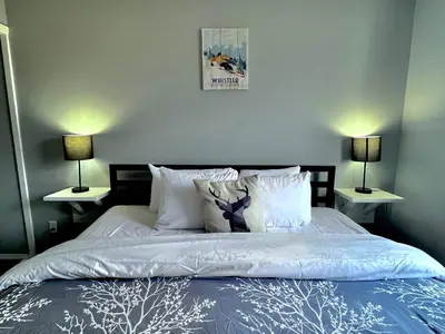 a bedroom with a bed with two lamps on both sides at Canadian Rockies Chalets by Trilink - 2 & 3 Bedroom Condos - Self Check-In - Walking Distance to Downtown - Free Parking - Pet-Friendly - No AC in Canmore