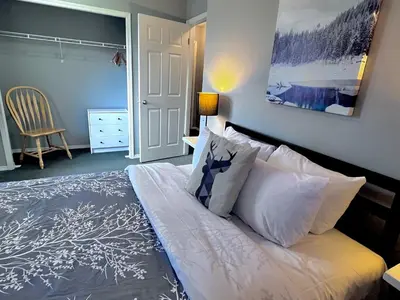 a bedroom with a bed with white pillows at Canadian Rockies Chalets by Trilink - 2 & 3 Bedroom Condos - Self Check-In - Walking Distance to Downtown - Free Parking - Pet-Friendly - No AC in Canmore