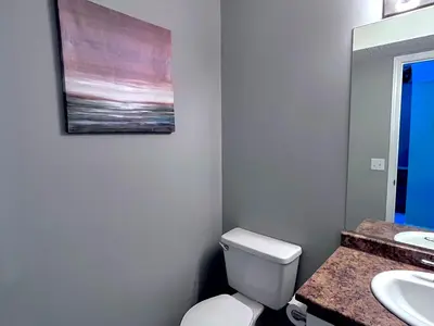 a bathroom with a toilet and a painting on the wall at Canadian Rockies Chalets by Trilink - 2 & 3 Bedroom Condos - Self Check-In - Walking Distance to Downtown - Free Parking - Pet-Friendly - No AC in Canmore