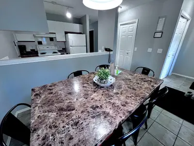 a kitchen and dining room table with a granite counter top at Canadian Rockies Chalets by Trilink - 2 & 3 Bedroom Condos - Self Check-In - Walking Distance to Downtown - Free Parking - Pet-Friendly - No AC in Canmore