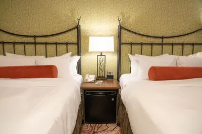 a hotel room with two beds and a table with a lamp at Banff Caribou Lodge and Spa in Banff