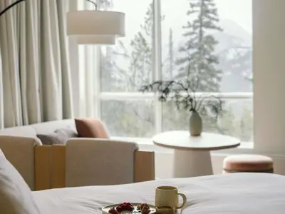 a room with a bed and a couch and a window at Rimrock Banff, Emblems Collection in Banff