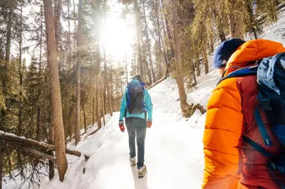two people walking down a snow covered trail at Banff Park Lodge in Banff