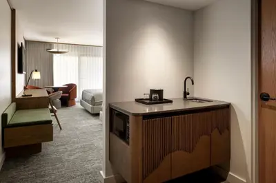 a kitchen with a sink and a living room at Banff Park Lodge in Banff