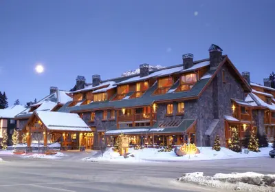a large lodge in the snow at night at Fox Hotel and Suites in Banff
