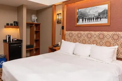 a hotel room with a bed with white pillows at Banff Ptarmigan Inn in Banff