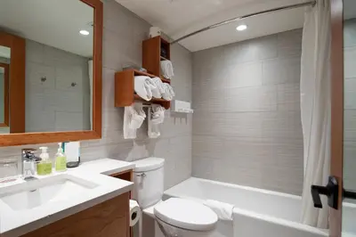 a bathroom with a tub and a toilet and a sink at Banff Ptarmigan Inn in Banff