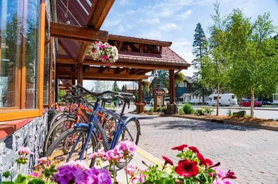 a bike parked in front of a building with flowers at Banff Ptarmigan Inn in Banff