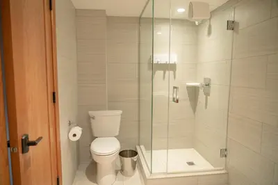 a bathroom with a toilet and a glass shower at Banff Ptarmigan Inn in Banff
