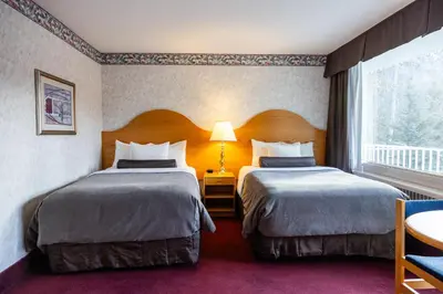 a hotel room with two beds and a window at Bow View Lodge in Banff