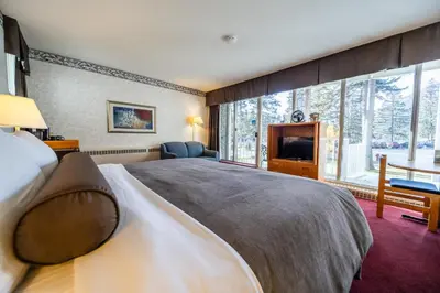a bedroom with a large bed and a large window at Bow View Lodge in Banff