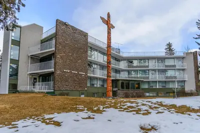 a large building with a wooden cross in front of it at Bow View Lodge in Banff