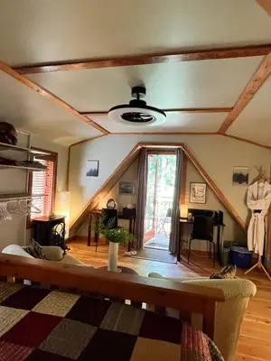 a living room with a couch and a ceiling at Five Elements Lodge B&B with Outdoor Spa in Fernwood