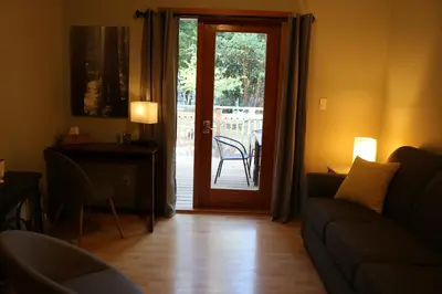 a living room with a couch and a sliding glass door at Five Elements Lodge B&B with Outdoor Spa in Fernwood
