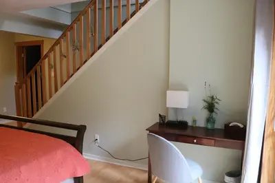 a bedroom with a bed and a desk and a staircase at Five Elements Lodge B&B with Outdoor Spa in Fernwood