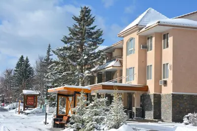 a building with a sign in the snow at Red Carpet Inn in Banff