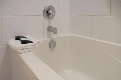 a bathroom with a bath tub with a sink at Red Carpet Inn in Banff