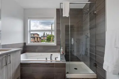 a bathroom with a bath tub and a window at Contemporary Luxury 4 bedroom House near Downtown in Calgary