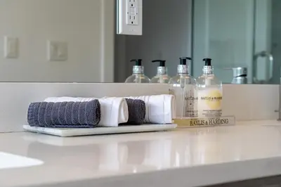 a bathroom counter with towels and bottles of alcohol at Contemporary Luxury 4 bedroom House near Downtown in Calgary