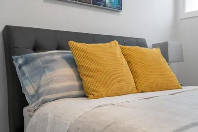 a bed with two yellow pillows on top of it at Contemporary Luxury 4 bedroom House near Downtown in Calgary