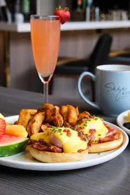 a plate with a sandwich and french fries and a drink at Delta Hotels by Marriott Calgary South in Calgary