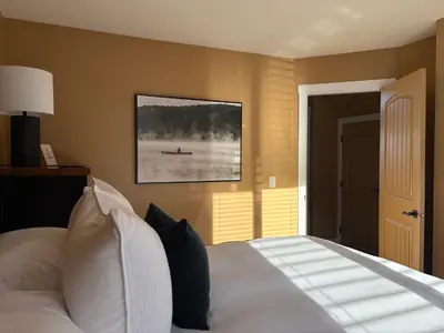 a bedroom with a bed and a painting on the wall at Exceptional Boutique Cottage with Incredible Lake View in Kelowna