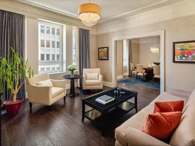 a living room with a couch and chairs and a table at Fairmont Palliser in Calgary