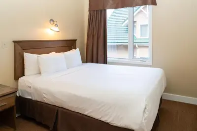 a large bed in a hotel room with a window at Irwin's Mountain Inn in Banff
