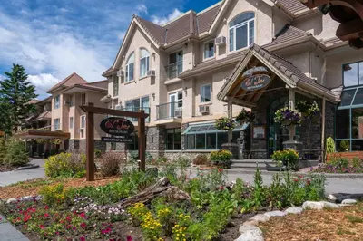 a building with a flower garden in front of it at Irwin's Mountain Inn in Banff