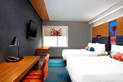 a hotel room with two beds and a desk at Aloft Hotel Calgary University in Calgary