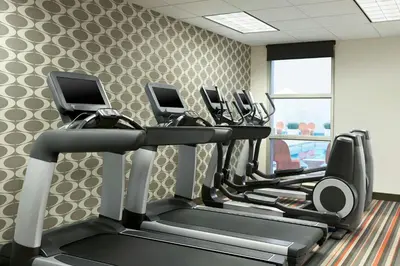 a gym with several tread machines in a room at Aloft Hotel Calgary University in Calgary