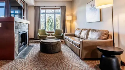 a living room with a couch and a fireplace at Blackstone Mountain Lodge by CLIQUE in Canmore