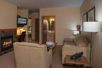 a living room with two chairs and a fireplace at Lodges at Canmore in Canmore