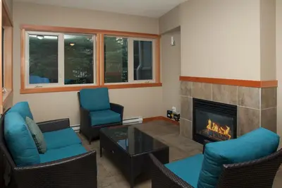 a living room with chairs and a fireplace at Lodges at Canmore in Canmore