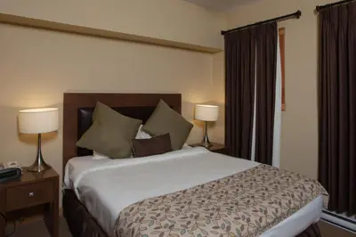 a hotel room with a large bed with two lamps at Lodges at Canmore in Canmore