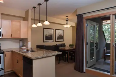 an open kitchen and dining room with a dining table at Lodges at Canmore in Canmore