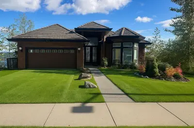 a house with a green lawn with a garage at Seaview Executive Home in Ladysmith