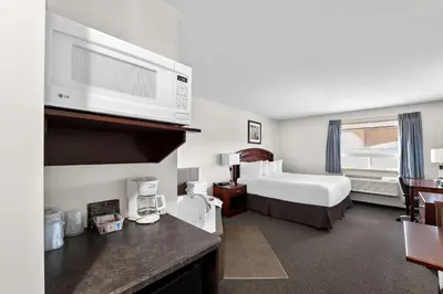 a hotel room with a bed and a microwave at SureStay Plus Hotel by Best Western Hardisty in Hardisty