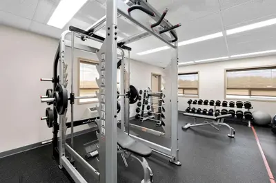 a gym with two treadmills and weights at SureStay Plus Hotel by Best Western Hardisty in Hardisty