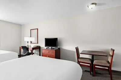 a bedroom with a bed and a desk and a television at SureStay Plus Hotel by Best Western Hardisty in Hardisty