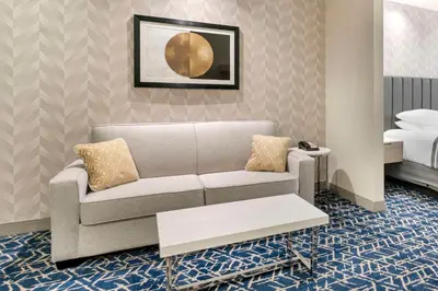 a living room with a couch and a bed at Best Western Premier Route 97 Vernon in Vernon