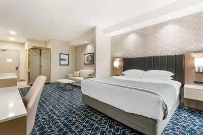 a hotel room with a large bed and a living room at Best Western Premier Route 97 Vernon in Vernon