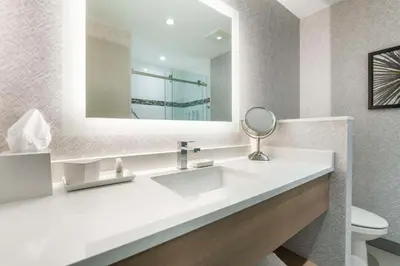 a bathroom with a white sink and a mirror at Best Western Premier Route 97 Vernon in Vernon