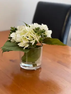 a vase filled with white flowers sitting on a table at Best ski in ski out condo at Whistler in Whistler