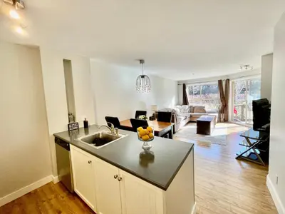 a kitchen with a sink and a living room at Best ski in ski out condo at Whistler in Whistler