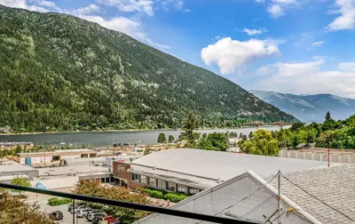 a view of a town with a river and mountains at Stirling All Suites Hotel in Nelson