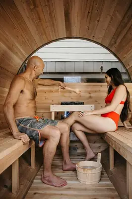 a man and a woman sitting in a sauna at Stirling All Suites Hotel in Nelson