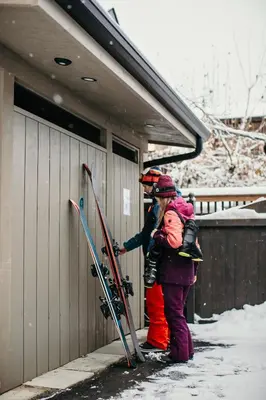 two people are standing next to a building with their skis at Stirling All Suites Hotel in Nelson