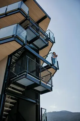a man sitting on a balcony of a building at Stirling All Suites Hotel in Nelson